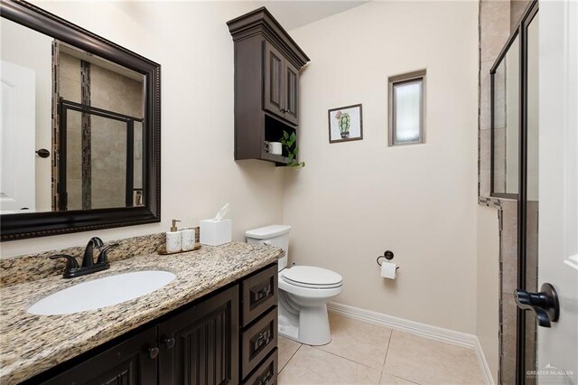 bathroom with tile patterned floors, vanity, toilet, and a shower with shower door