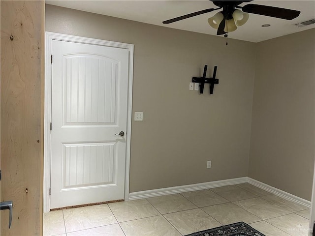 interior space with a ceiling fan, visible vents, baseboards, and light tile patterned floors