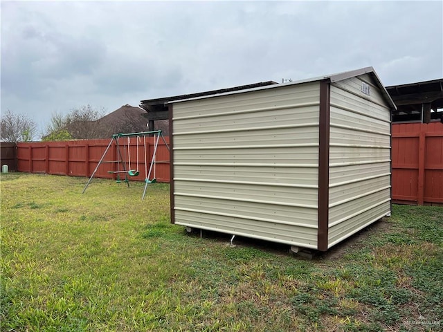 view of shed with a fenced backyard and a playground