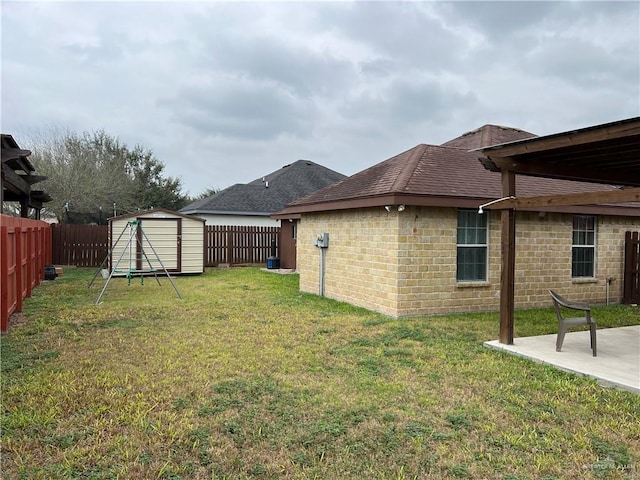 view of yard with an outbuilding, a patio area, a fenced backyard, and a shed