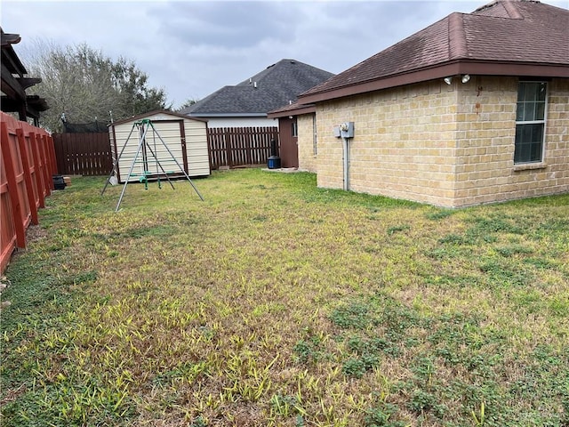 view of yard featuring a fenced backyard, an outdoor structure, and a storage unit