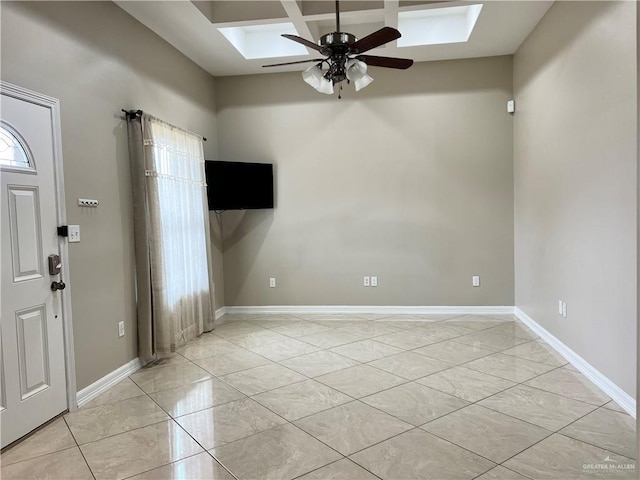 entrance foyer featuring a skylight, ceiling fan, baseboards, and coffered ceiling