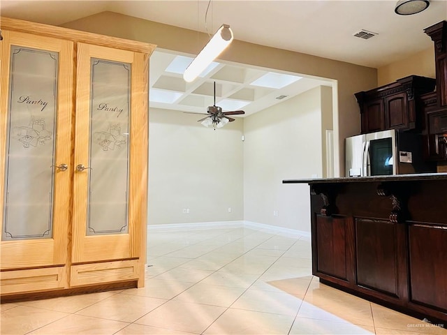 kitchen featuring light tile patterned floors, ceiling fan, coffered ceiling, baseboards, and fridge