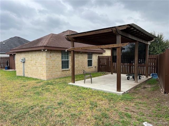 exterior space featuring a patio, brick siding, a lawn, and fence private yard