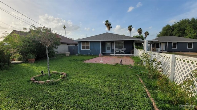 back of house with a yard and a patio