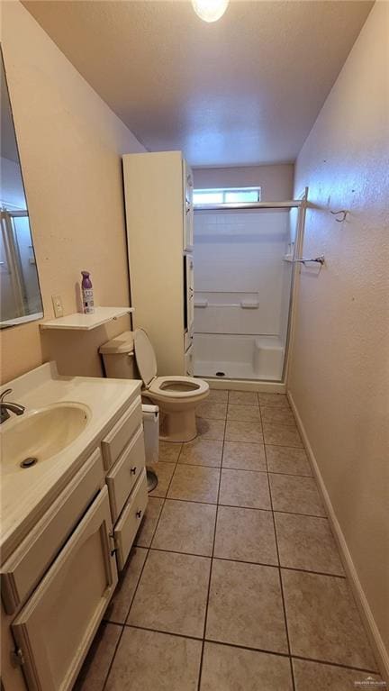 bathroom featuring toilet, vanity, tile patterned floors, and walk in shower