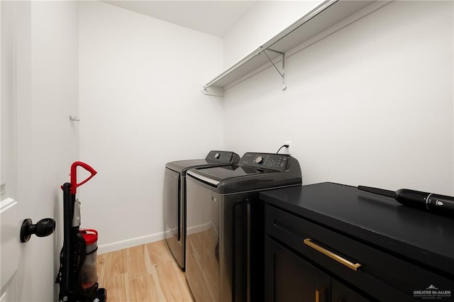 laundry area with washing machine and clothes dryer, light wood-style floors, and baseboards