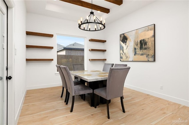 dining space with a chandelier, baseboards, beamed ceiling, and wood finished floors