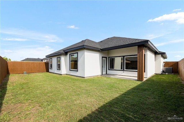 rear view of property featuring central AC, a fenced backyard, stucco siding, a lawn, and roof with shingles