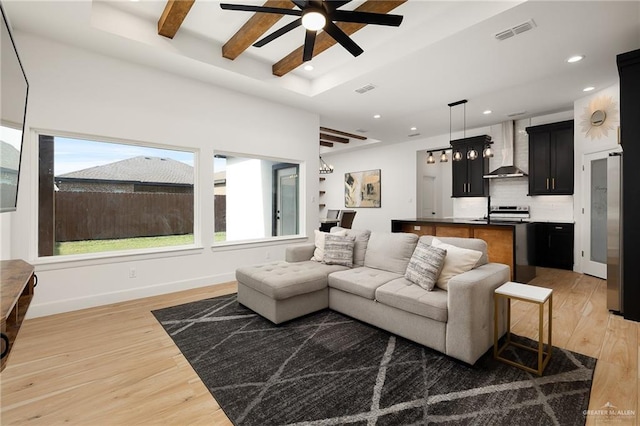living area featuring visible vents, baseboards, ceiling fan, light wood-type flooring, and recessed lighting