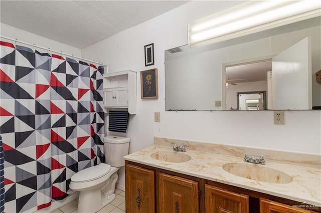 bathroom featuring tile patterned flooring, a sink, toilet, and double vanity