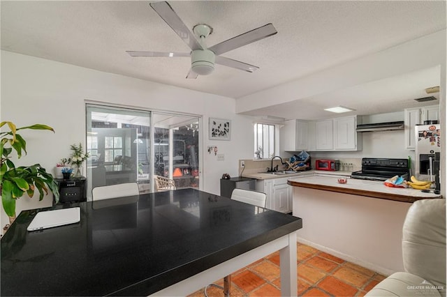 kitchen with stainless steel fridge with ice dispenser, light countertops, black electric range, white cabinetry, and a sink