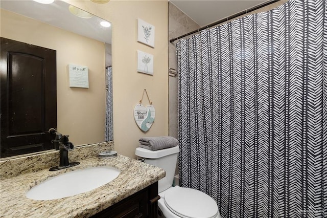 bathroom with a shower with shower curtain, vanity, and toilet