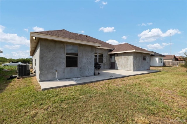 back of house with cooling unit, a yard, and a patio