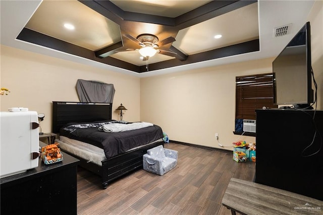 bedroom featuring a tray ceiling, ceiling fan, and dark wood-type flooring