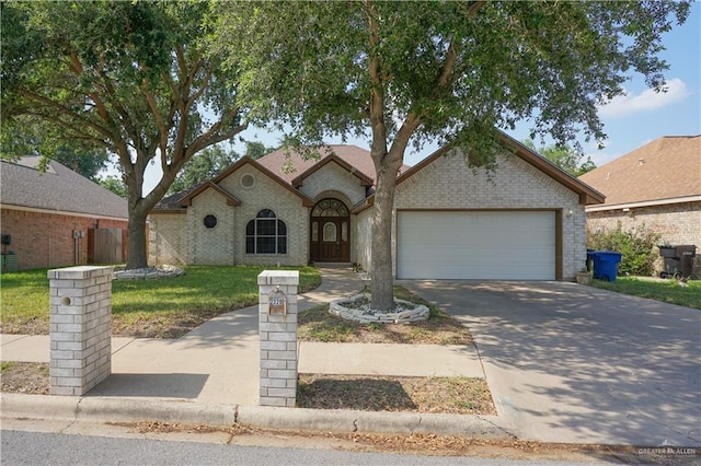 2320 Pelican Ave, Mcallen, TX 78504 - view of front of property featuring a garage, driveway, brick siding, and a front yard