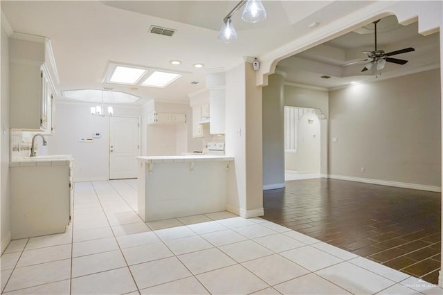 2320 Pelican Ave, Mcallen, TX 78504 - kitchen with crown molding, a peninsula, open floor plan, tile countertops, and a ceiling fan