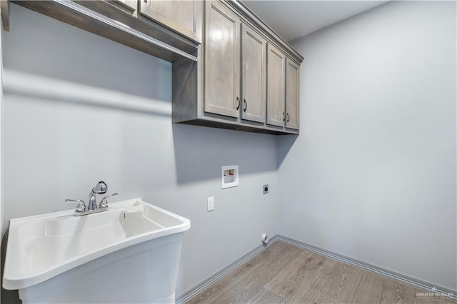 washroom with washer hookup, electric dryer hookup, cabinet space, a sink, and light wood finished floors