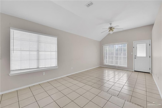 spare room with light tile patterned flooring, vaulted ceiling, and ceiling fan