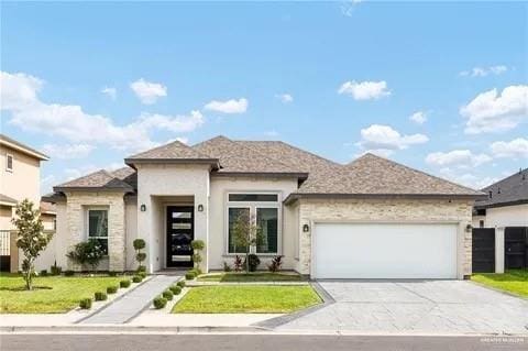 view of front of house featuring a garage, concrete driveway, and a front lawn