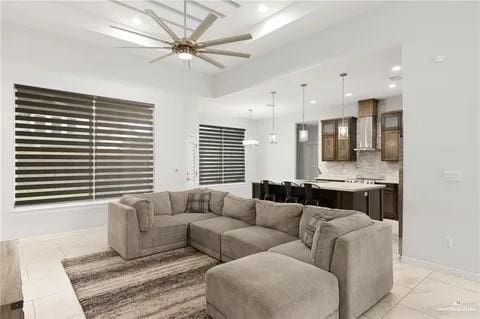 living area with light tile patterned floors, ceiling fan, baseboards, and recessed lighting