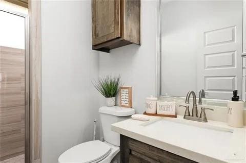 bathroom featuring toilet and vanity