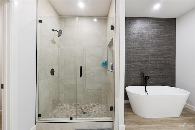 bathroom featuring hardwood / wood-style flooring and shower with separate bathtub