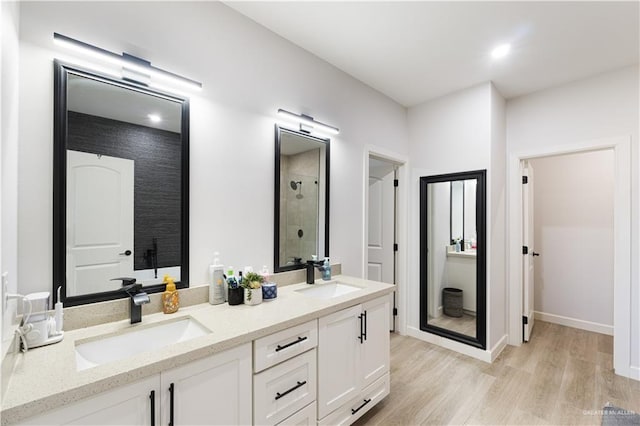 bathroom featuring hardwood / wood-style flooring, walk in shower, and vanity