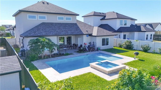 rear view of house with a pool with hot tub, central air condition unit, a patio area, and a lawn