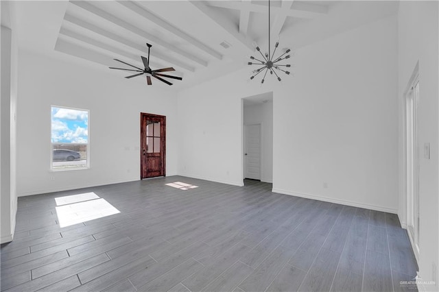 unfurnished living room with ceiling fan with notable chandelier, beam ceiling, a towering ceiling, and light hardwood / wood-style flooring