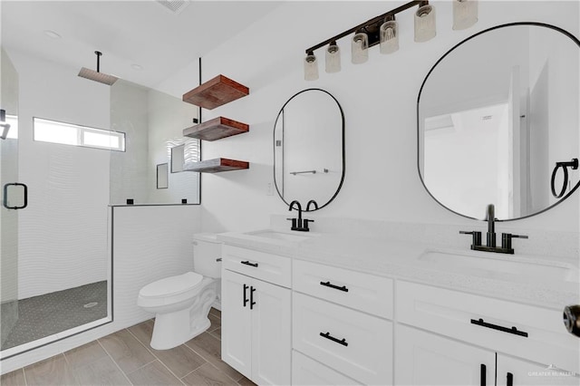 bathroom with hardwood / wood-style floors, vanity, toilet, and a shower with door