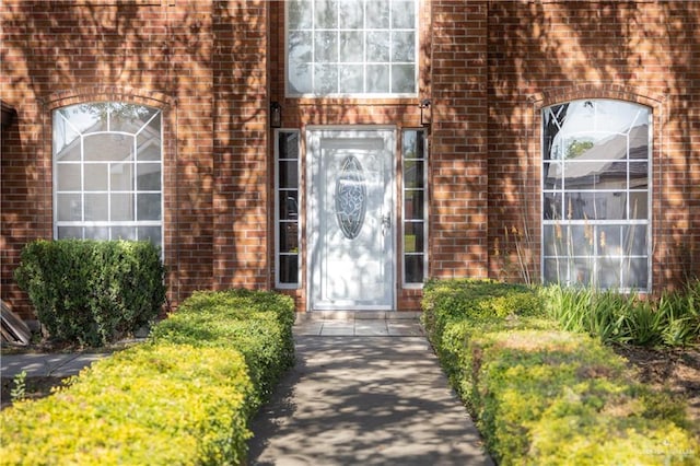 doorway to property featuring brick siding