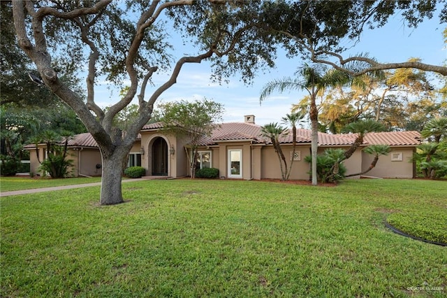 mediterranean / spanish house with a front yard