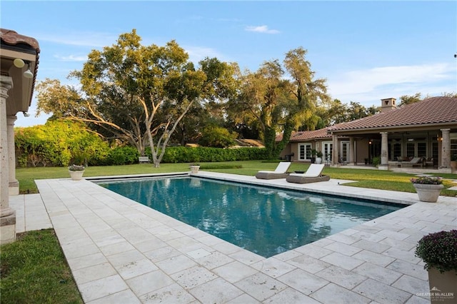 view of swimming pool with a yard and a patio