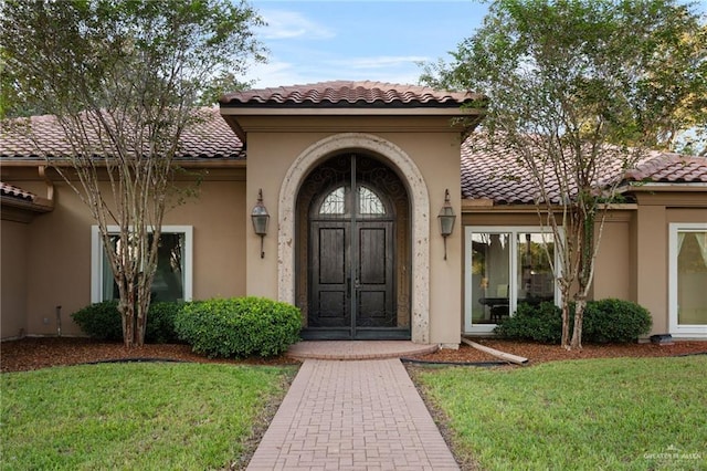 property entrance with a lawn