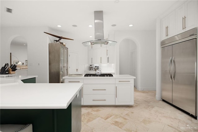 kitchen featuring white cabinets, island exhaust hood, and built in refrigerator