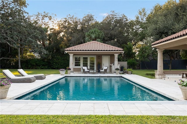 view of pool with an outbuilding, a patio, and a lawn