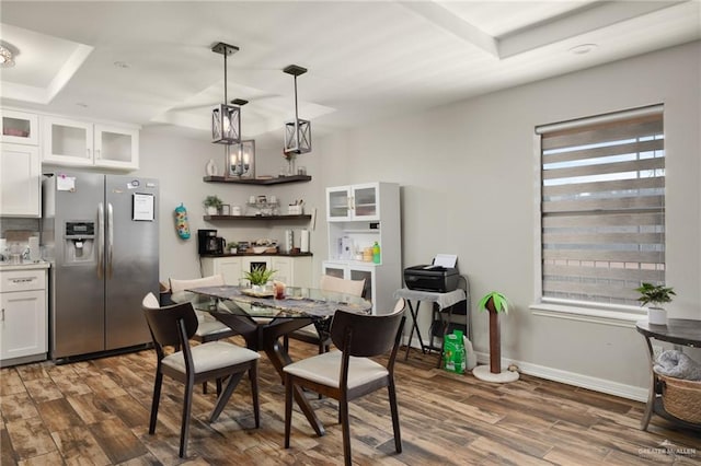 dining room featuring plenty of natural light, dark wood-type flooring, and a tray ceiling