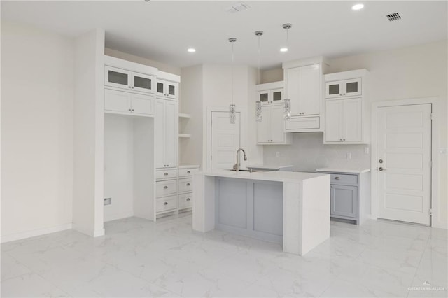 kitchen featuring visible vents, recessed lighting, a center island with sink, and marble finish floor