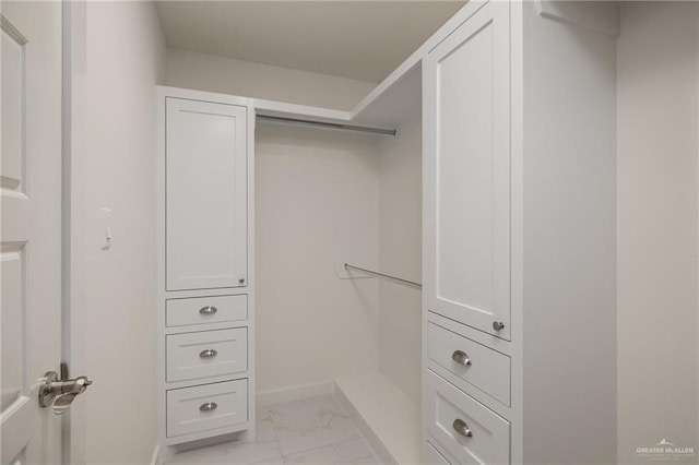 walk in closet with marble finish floor