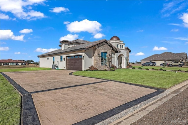 view of front of home featuring cooling unit, a garage, and a front yard