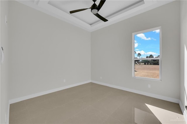 empty room featuring a raised ceiling and ceiling fan