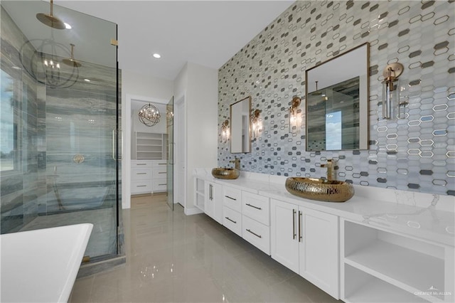 bathroom with a chandelier, vanity, a shower with door, tile patterned flooring, and decorative backsplash