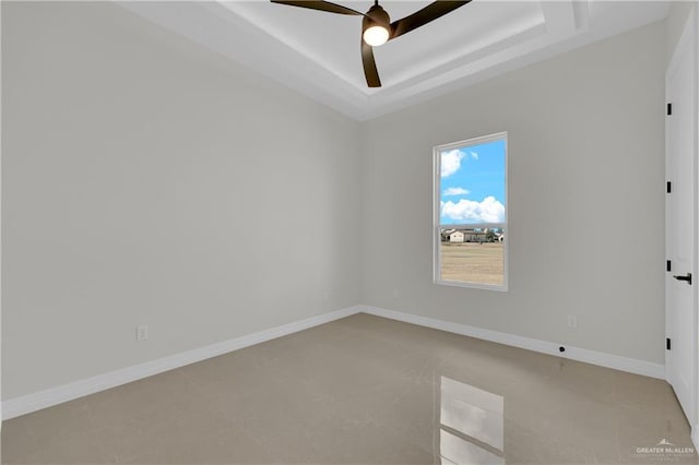 unfurnished room with a raised ceiling and ceiling fan