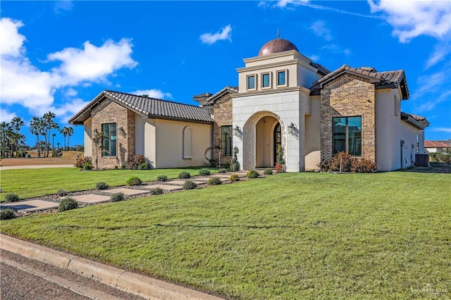 view of front of property with central AC and a front lawn