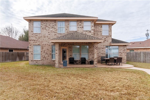 back of house with a fenced backyard, brick siding, a shingled roof, a yard, and a patio area