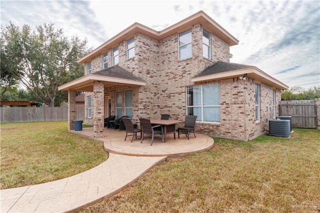 rear view of property with a lawn, a patio, fence, cooling unit, and brick siding