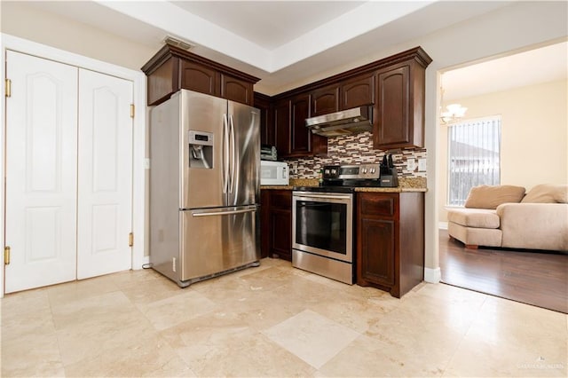 kitchen with stainless steel appliances, dark brown cabinets, backsplash, and under cabinet range hood