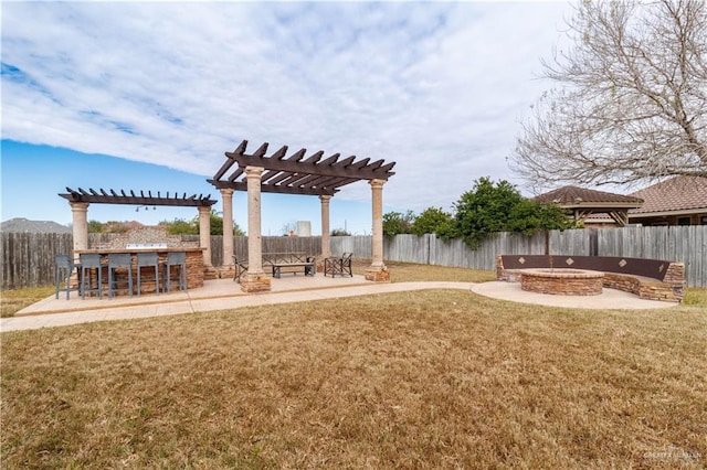 view of yard with outdoor dry bar, an outdoor fire pit, a patio area, a pergola, and a fenced backyard