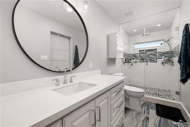 full bath with marble finish floor, vanity, a shower stall, and toilet